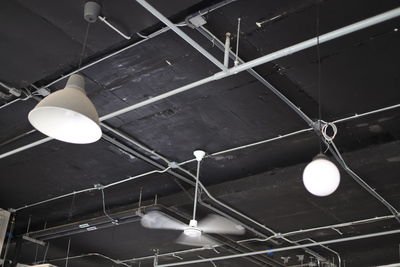 Low angle view of illuminated pendant light hanging from ceiling