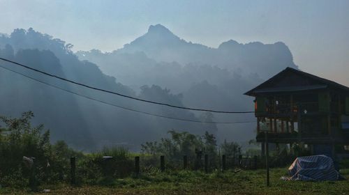 Built structure on field by mountain against sky