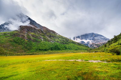 Scenic view of mountains against cloudy sky