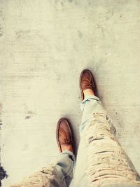 Low section of man standing on sand