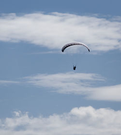 Low angle view of person paragliding against sky