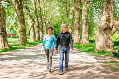 Full length of couple walking in forest
