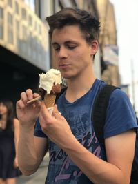 Man holding ice cream in city