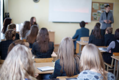 Rear view of students sitting in classroom