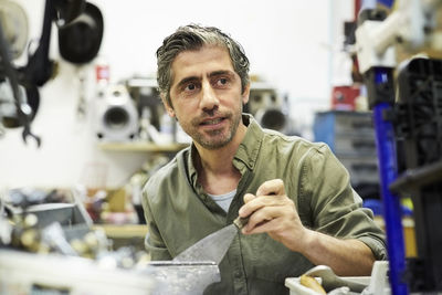 Mature man looking away while working in workshop