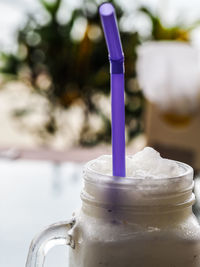 Close-up of milkshake with straw in mason jar