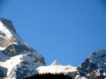 Scenic view of snowcapped mountains against clear blue sky