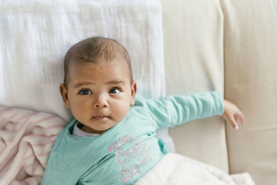 High angle view of cute baby lying on bed at home