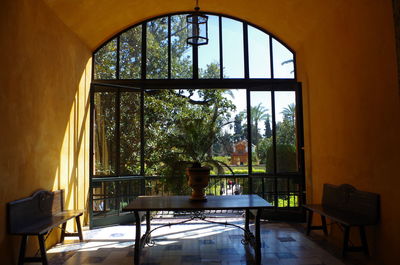 Empty chairs and table against window