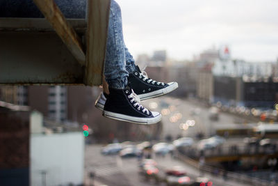 Low section of people wearing shoes against city street