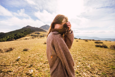 Woman standing on field against sky