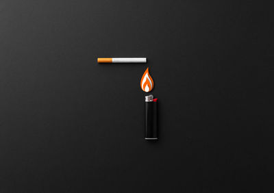 Close-up of lit candle against black background