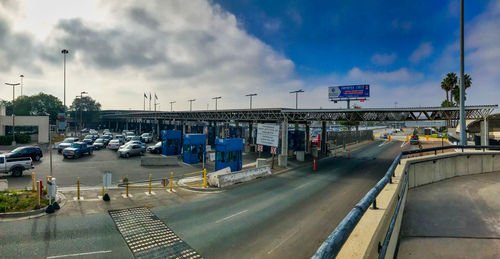 Cars on road against sky in city