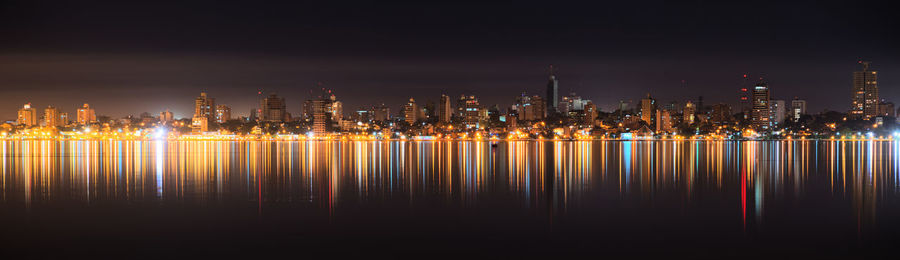 Illuminated cityscape against sky at night