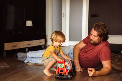 Dad and son playing cars at home