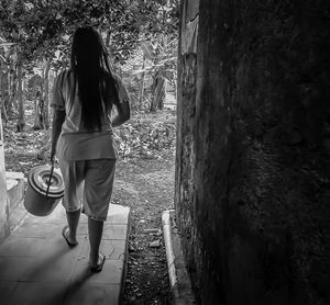 Rear view of women standing against trees