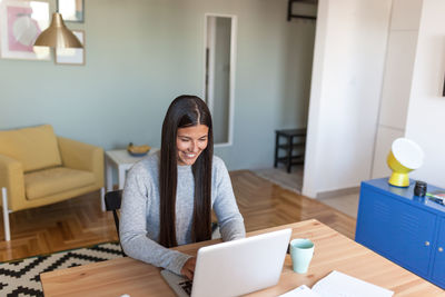 Woman sitting on table at home