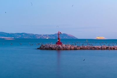 Lighthouse by sea against sky