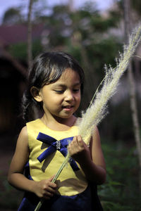 Portrait of young woman standing against trees