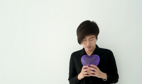 Young woman standing against white background