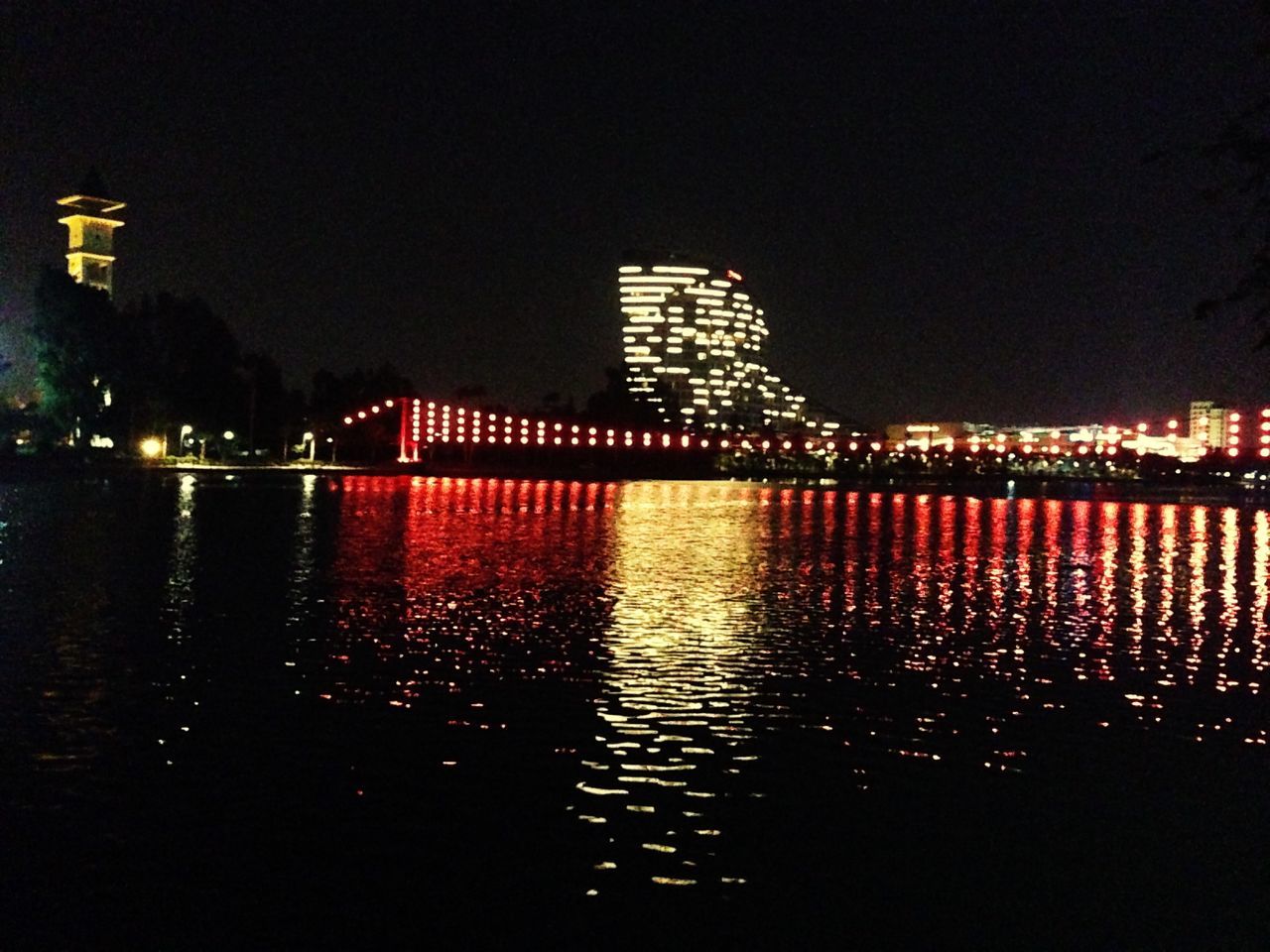 night, illuminated, architecture, built structure, building exterior, water, reflection, waterfront, river, city, clear sky, travel destinations, copy space, bridge - man made structure, tower, connection, famous place, mid distance, outdoors, sky