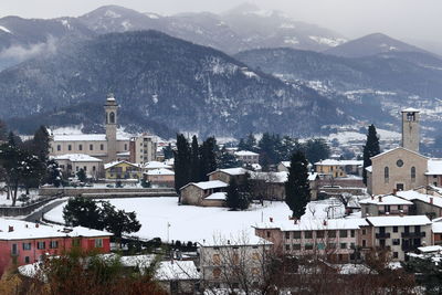 Buildings in town against mountain range in winter
