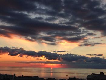 Scenic view of sea against cloudy sky during sunset