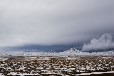 Scenic view of snow covered land against sky