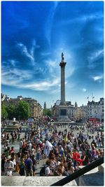 People in city against cloudy sky