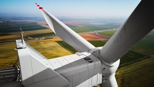 Aerial view of close up windmill turbine in countryside area, wind power and renewable energy