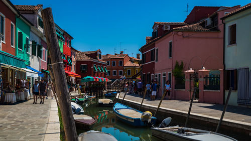 Buildings by canal against sky in city