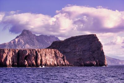 Scenic view of sea and mountains against sky