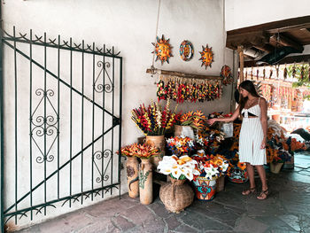 Young woman standing by flowers decorations for dia de los muertos