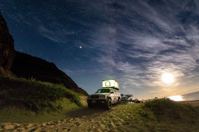 Road amidst field against sky at night