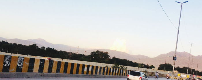 Cars on road against sky during sunset