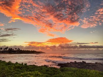 Scenic view of sea against cloudy sky during sunset