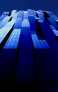 Low angle view of office building against blue sky