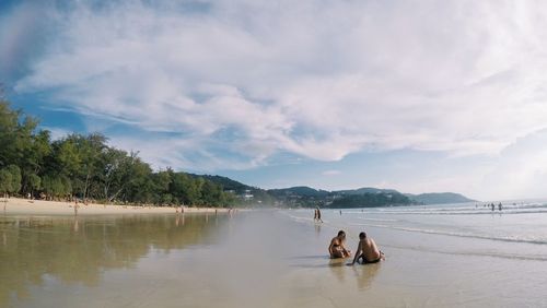 People on beach against sky
