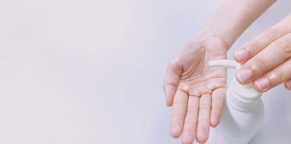 Close-up of person holding hands over white background