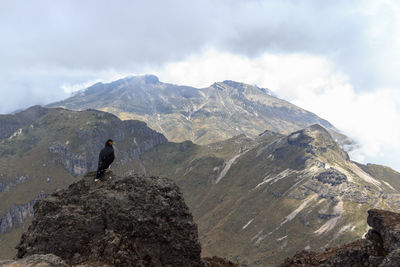 Man looking at mountain against sky