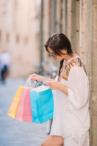 Midsection of woman holding umbrella in city