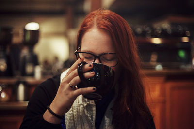 Portrait of a young woman drinking glass