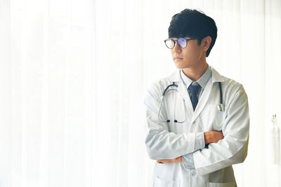 Full length of young man standing against wall