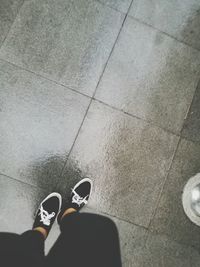 Low section of man standing on tiled floor