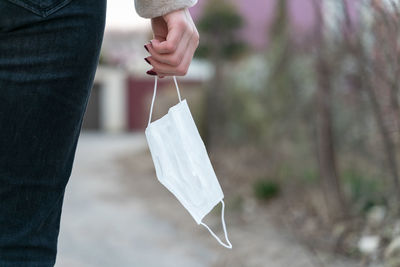 Midsection of man holding umbrella standing on paper