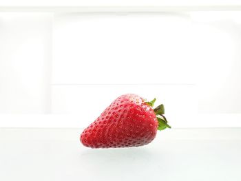 Close-up of strawberry on table against white background