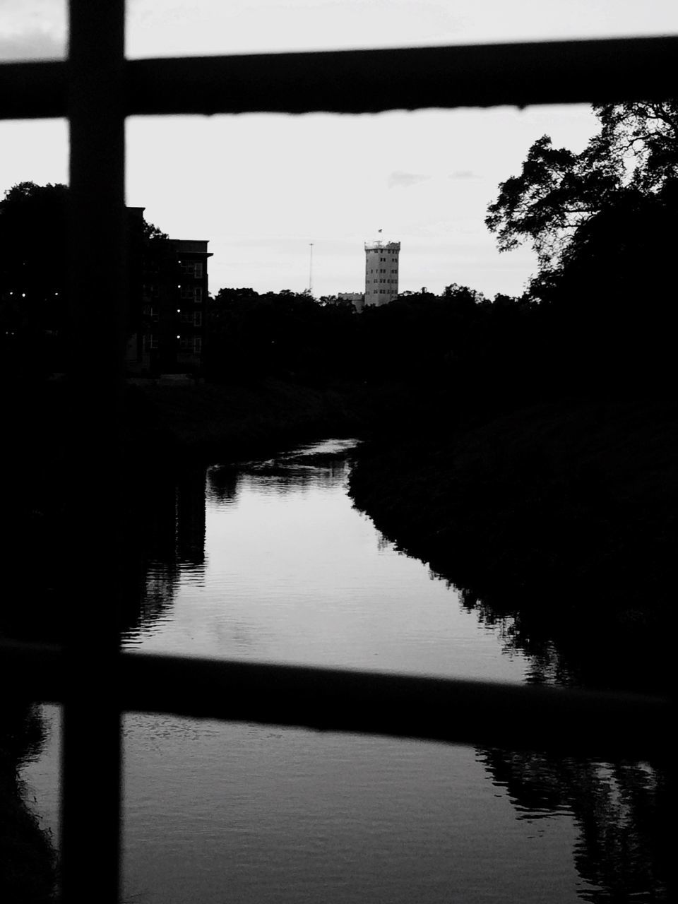 water, silhouette, reflection, tree, architecture, built structure, tranquility, calm, tranquil scene, dark, canal, day, sky, scenics, no people, waterfront, bridge, outline, standing water, long