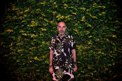 Portrait of man standing against plants