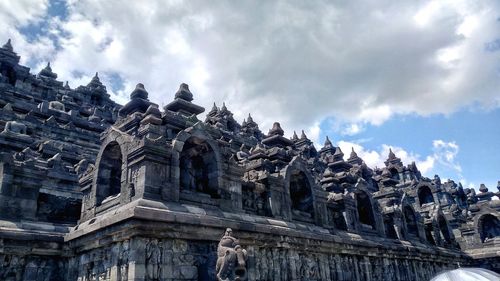 Low angle view of temple building against cloudy sky