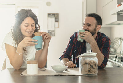 Happy young man drinking glasses on table
